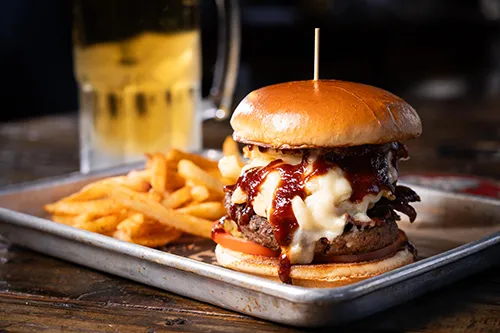 Barbecue burger with fries and cold beer at Red Rooster Ice House in Hawkins